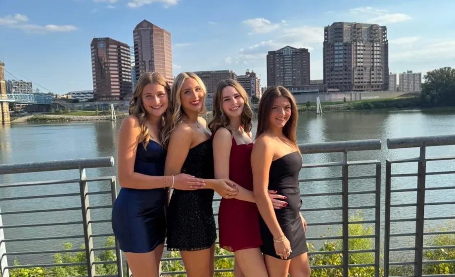 Vier Austauschschülerinnen in festlicher Kleidung vor Skyline und Flusskulisse in den USA